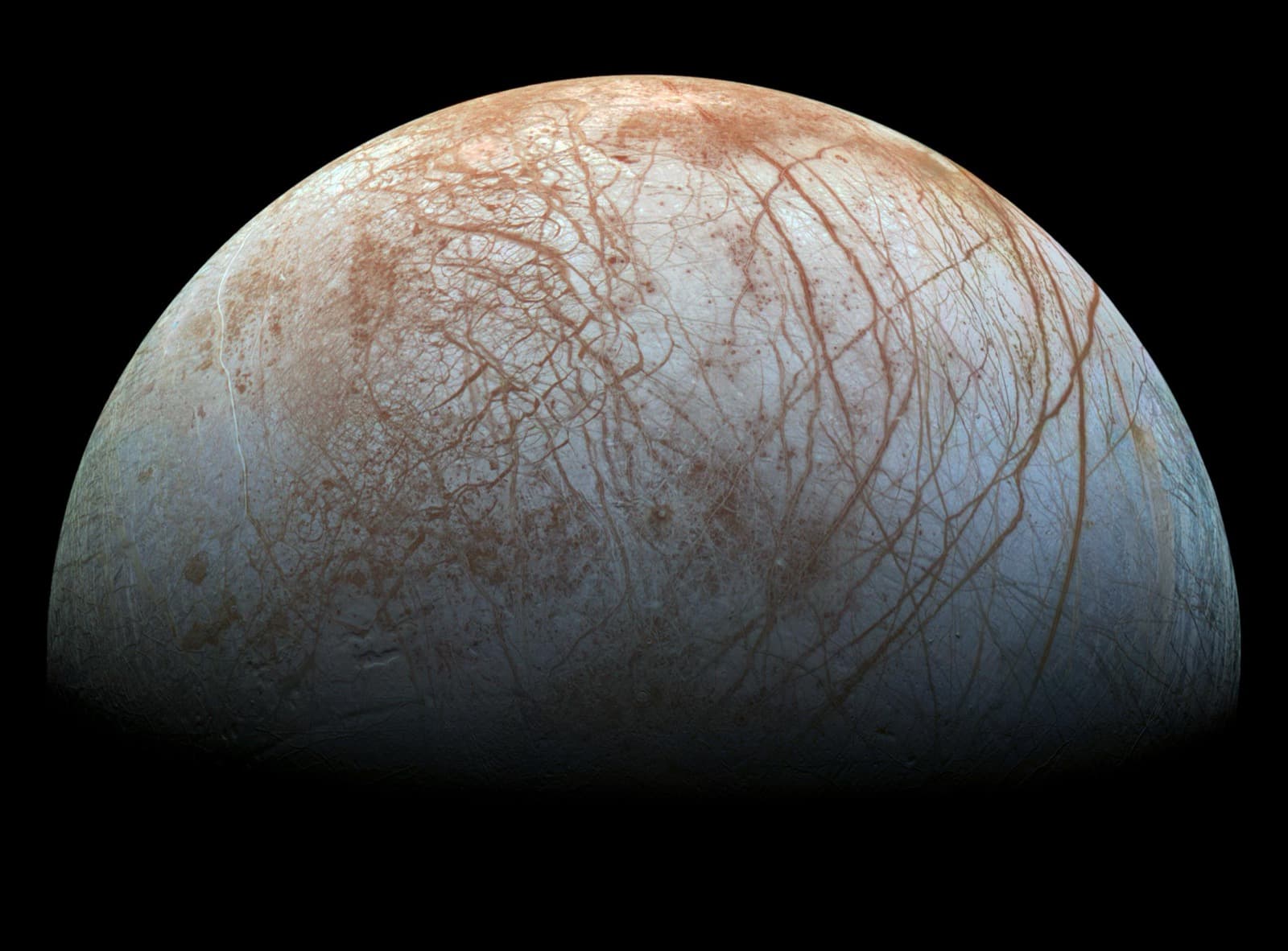 Reprocessed Galileo mosaic of Europa's pale ice crossed by dark reddish bands and fractures.