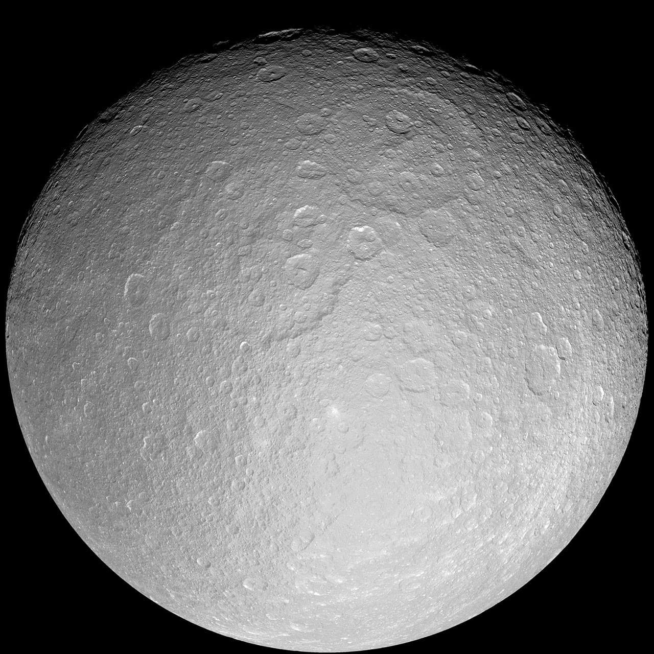 Cassini grayscale full-disk mosaic of Rhea showing an ancient surface packed with impact craters.